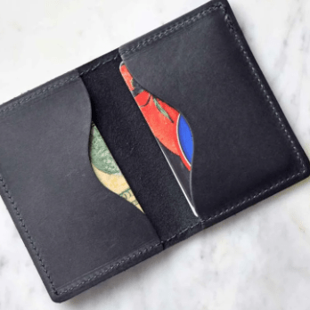 Full-grain leather bifold card wallet with multiple card slots, durable stitching, compact design for everyday organization, and effortless style. Black