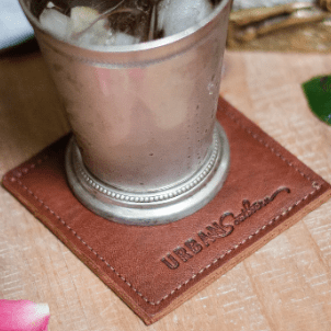 Set of square leather coasters in chestnut brown, handcrafted to protect surfaces and add style to your home.