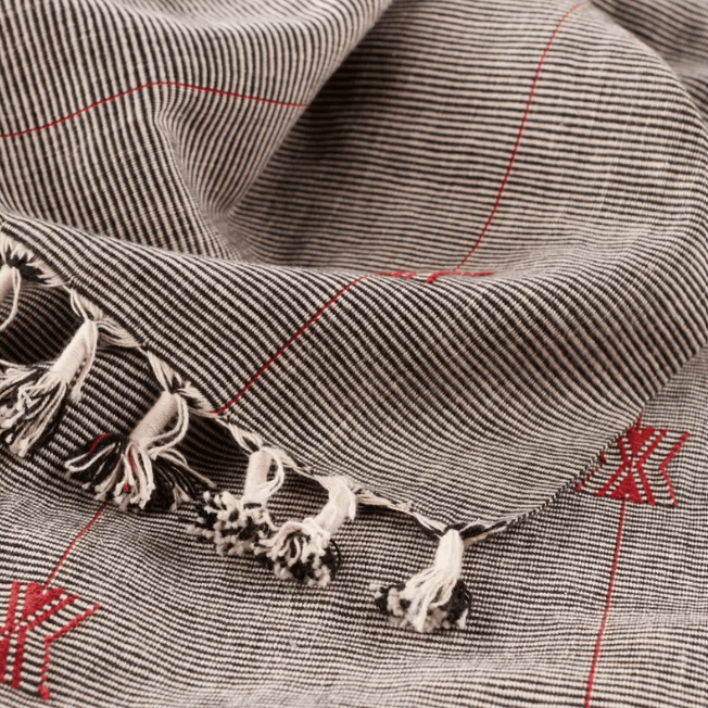 Nagaland Hebron handcrafted cotton throw blanket featuring tribal geometric design in black, red, and ivory; artisan-woven textile offering cultural flair and cozy texture for sofas, chairs, or beds.