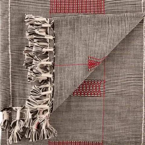 Nagaland Hebron handcrafted cotton throw blanket featuring tribal geometric design in black, red, and ivory; artisan-woven textile offering cultural flair and cozy texture for sofas, chairs, or beds.