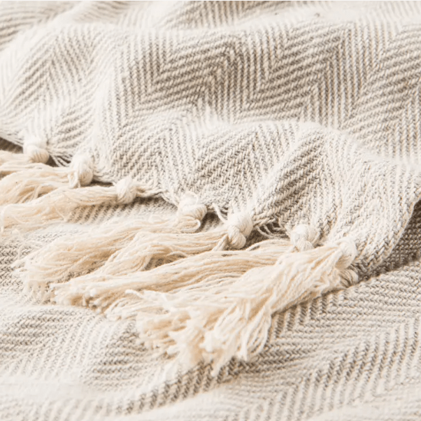 Seabreeze handcrafted cotton throw blanket in herringbone stripe pattern; soft, breathable textile ideal for layering on sofas, chairs, or beds, adding coastal-inspired style to home décor.  Beige
